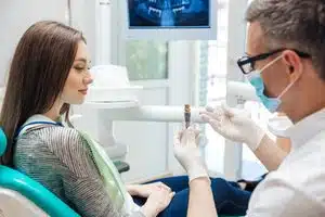 Dentist showing patient a dental implant.