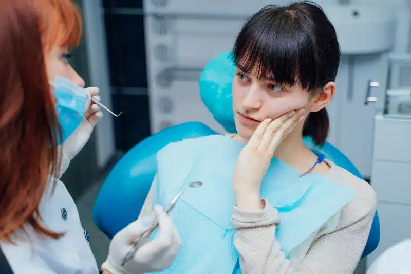 Woman in pain looking at her dentist