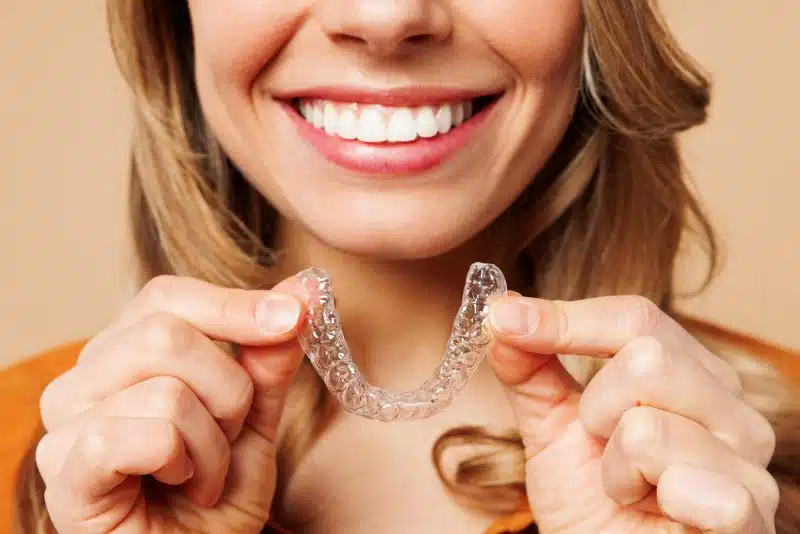 Woman putting on her clear aligners